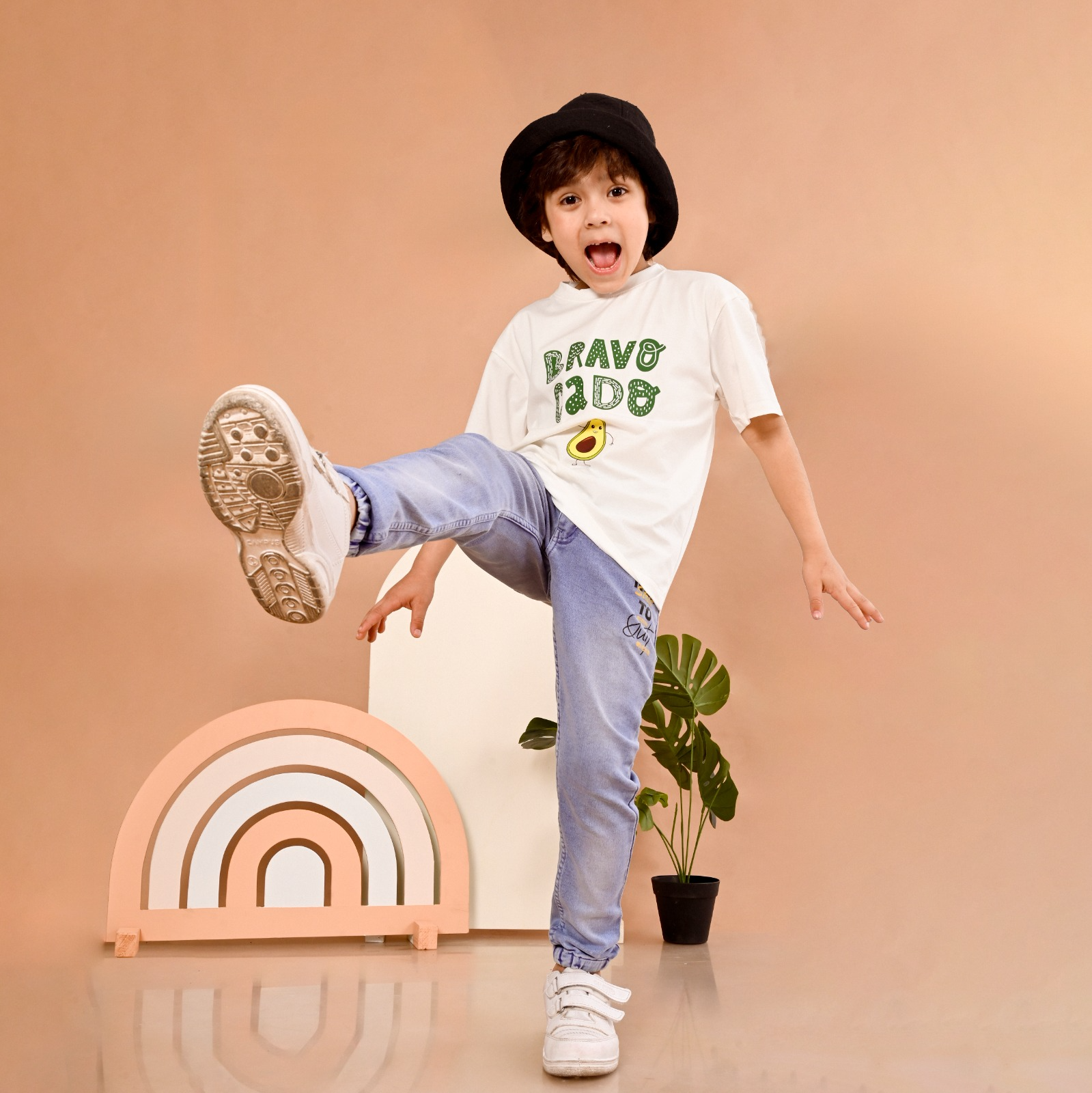 Kid wearing T shirt made with premium stitching, one destination to find travel t shirts for Child, playful view.