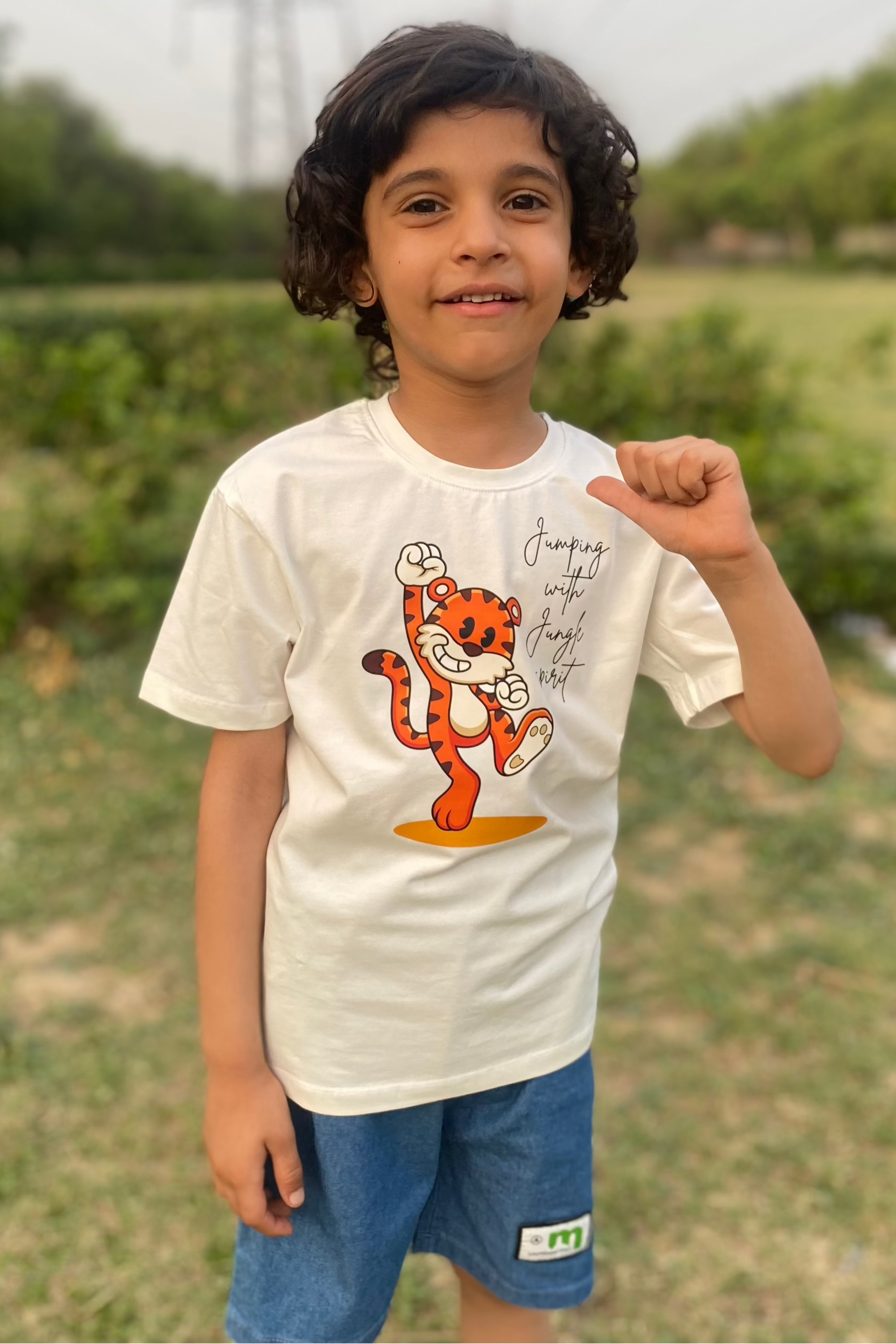 Child wearing an ultra soft off white t-shirt with a tiger print 