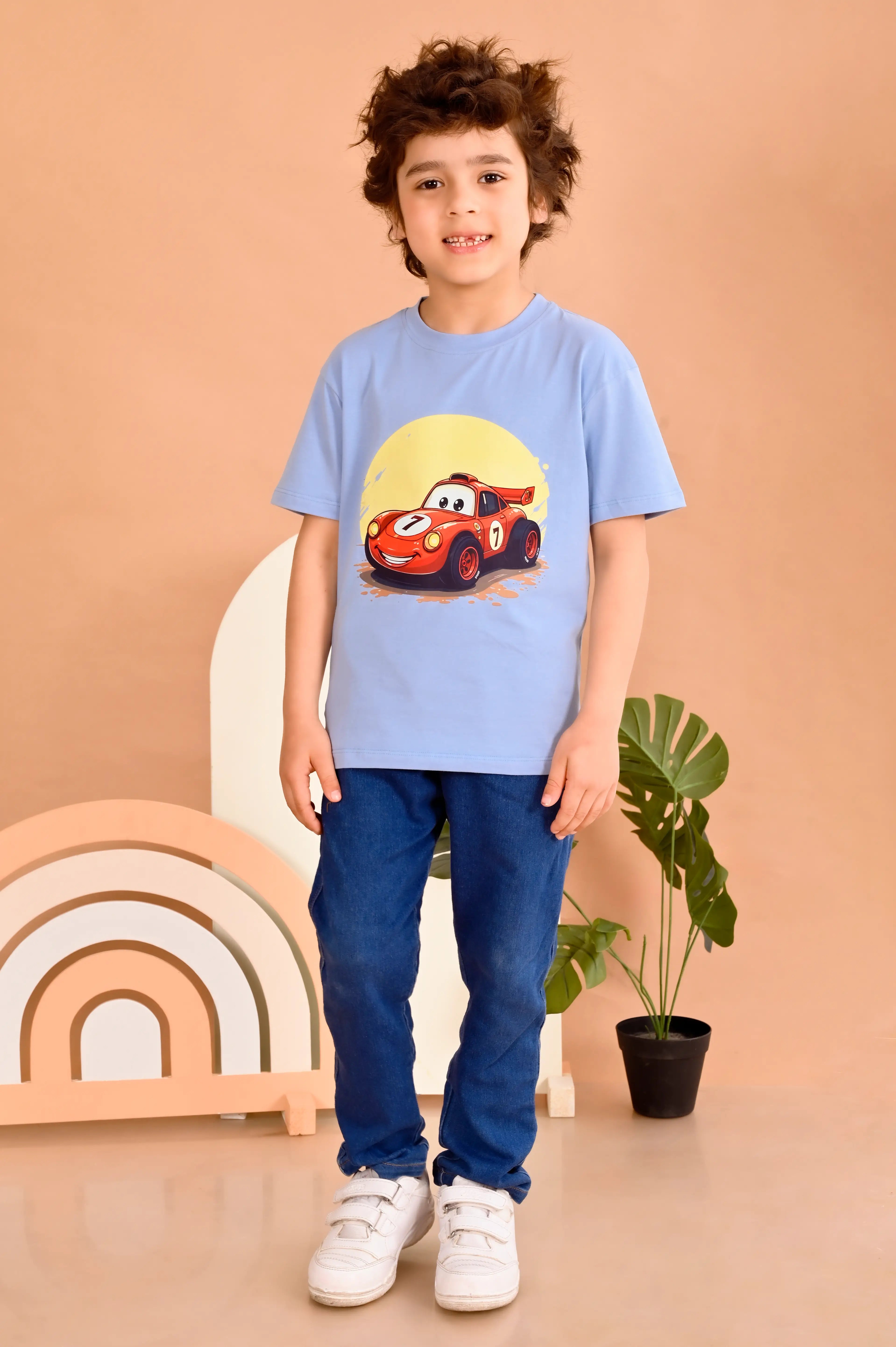 Child wearing an ash blue round neck  t-shirt with a red car graphic on it 