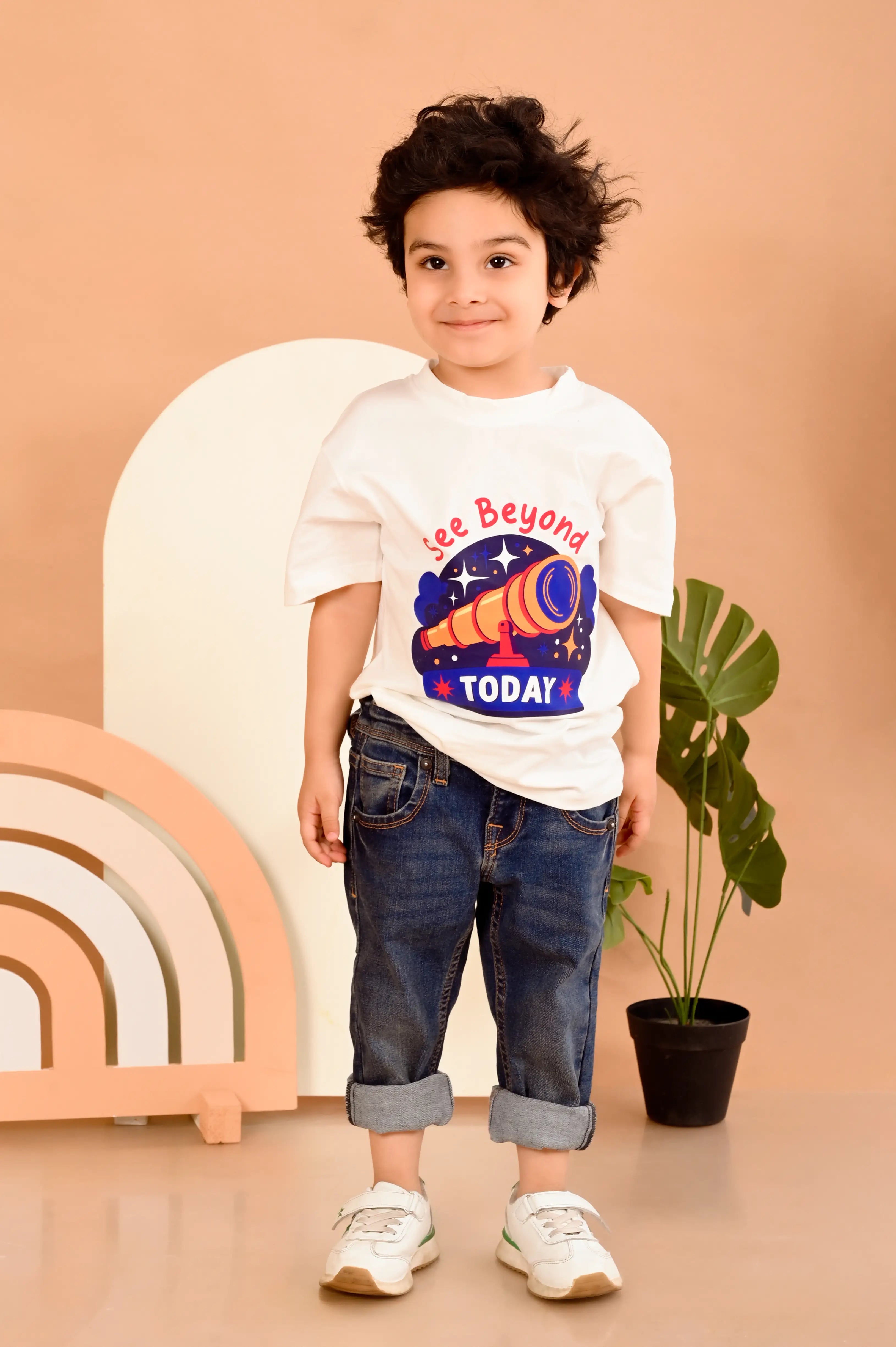 Child wearing an off white t-shirt with a telescope print , made from premium cotton fabric 