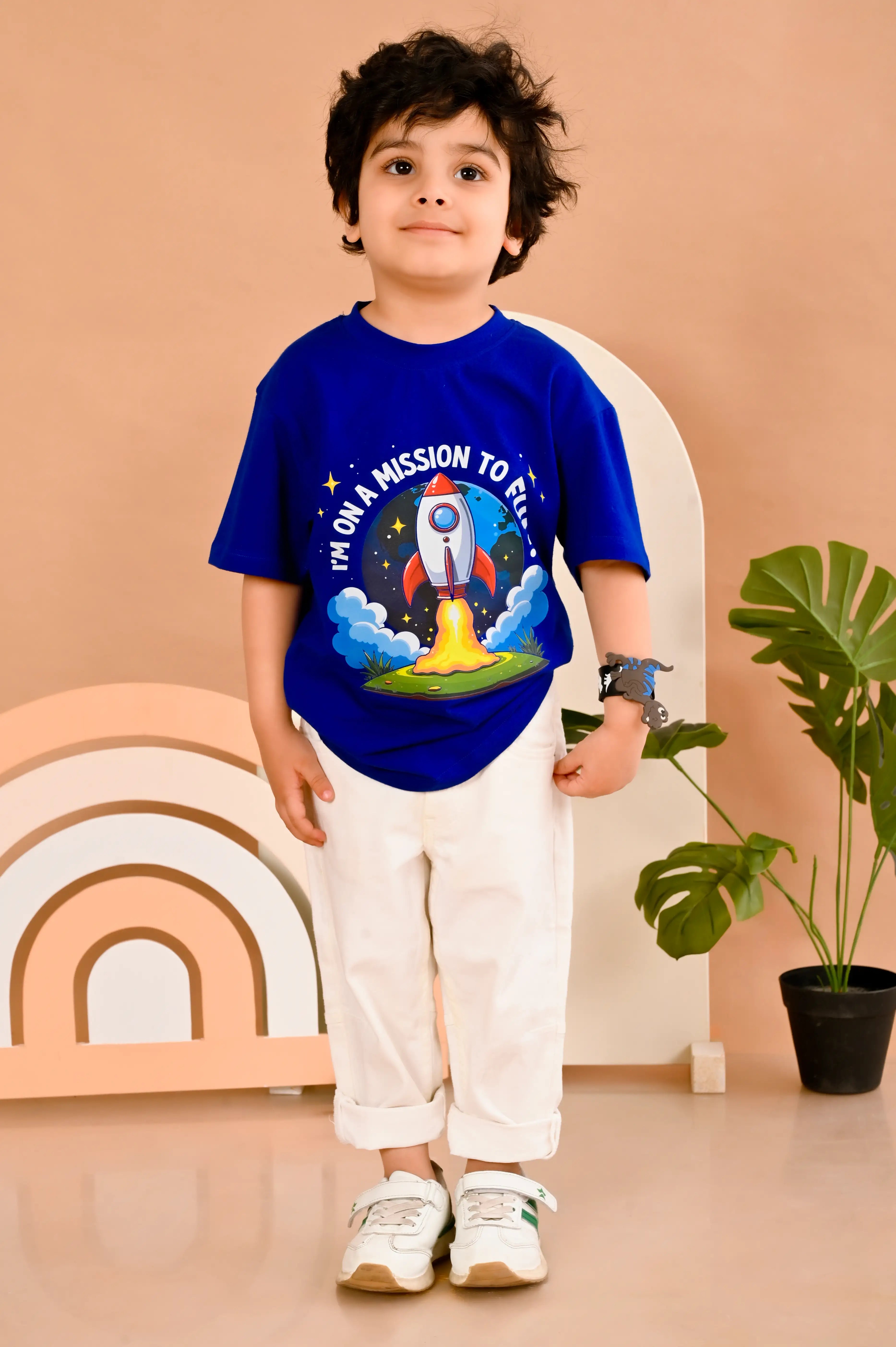Child wearing a royal blue round neck  t-shirt with a rocket design