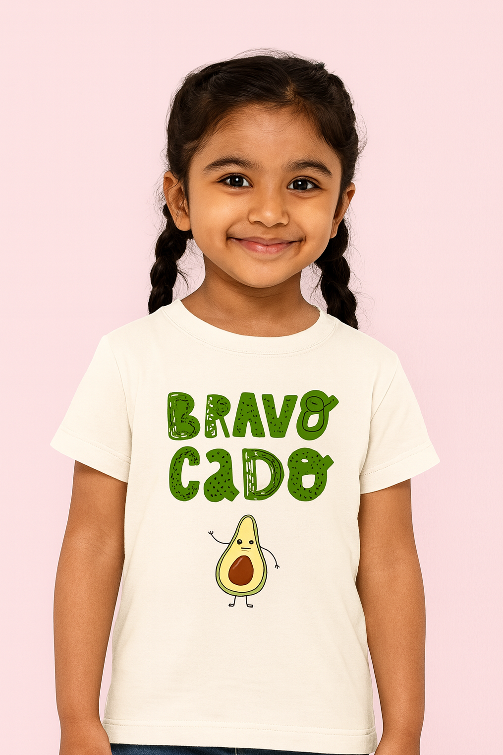 Child wearing a t-shirt with 'BRAVO CADO' and an avocado graphic on a pink background