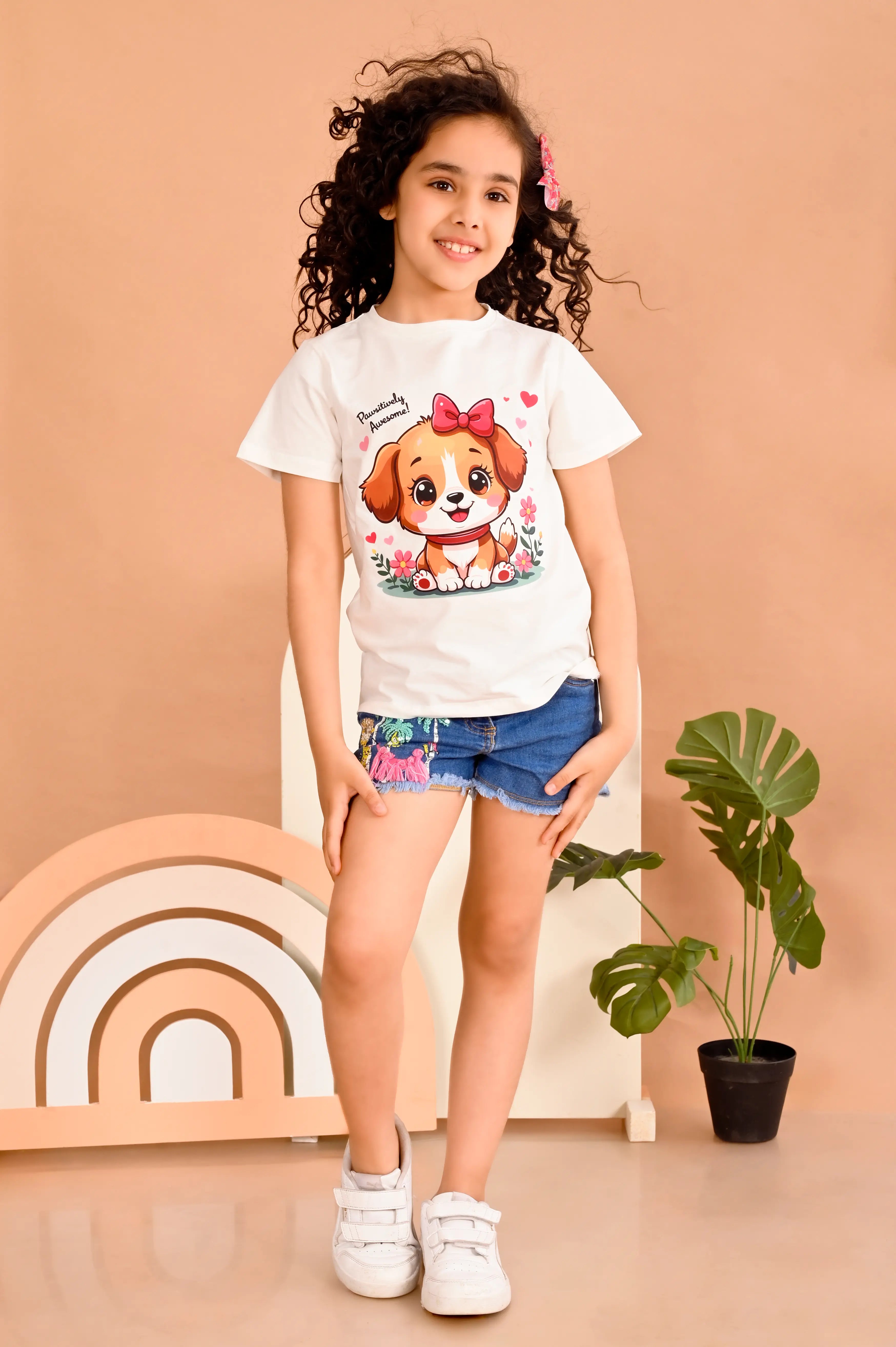 wearing a white t-shirt with a pet dog print and "positively pawsome" text 