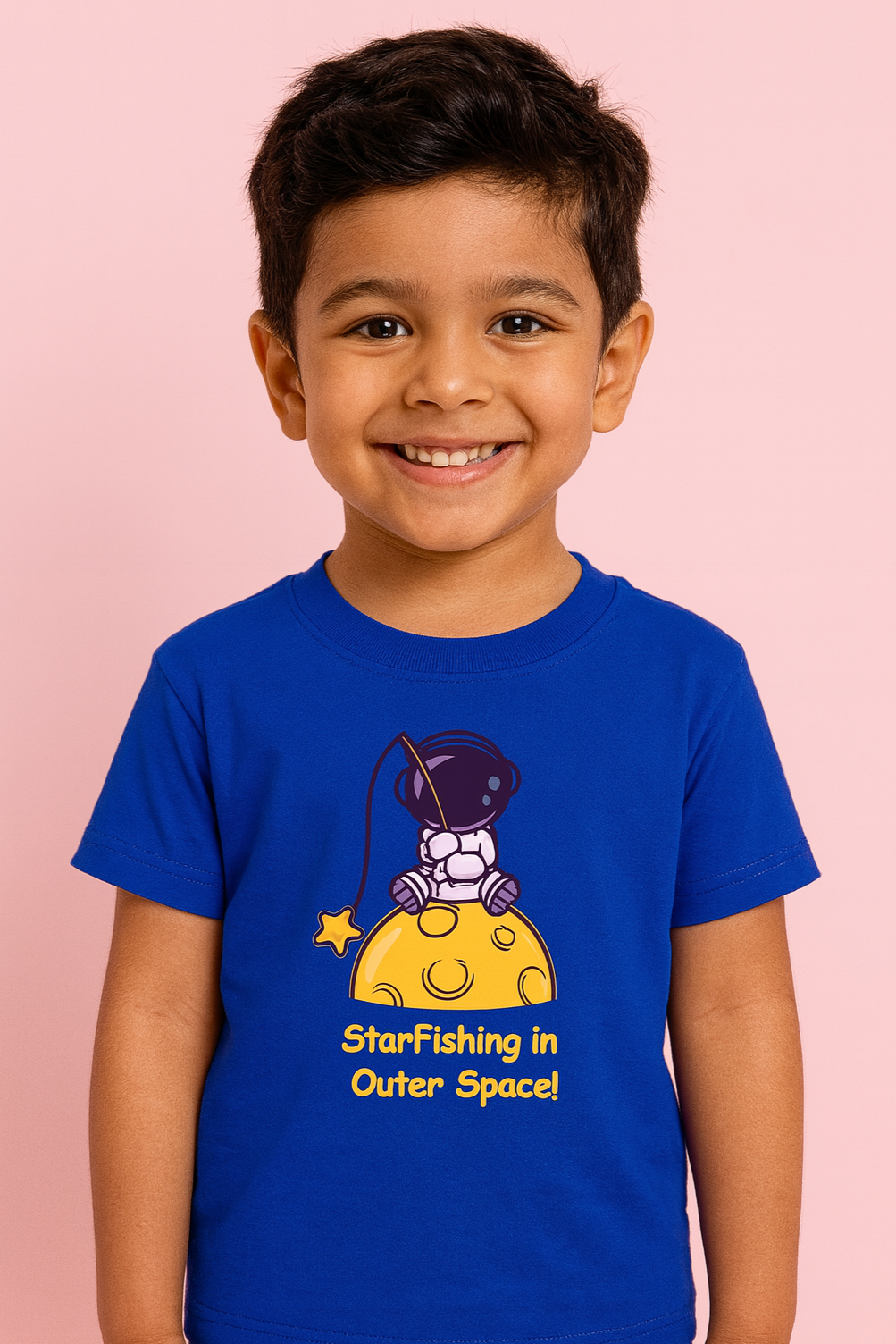 Child wearing a blue t-shirt with a space-themed graphic and text on a pink background