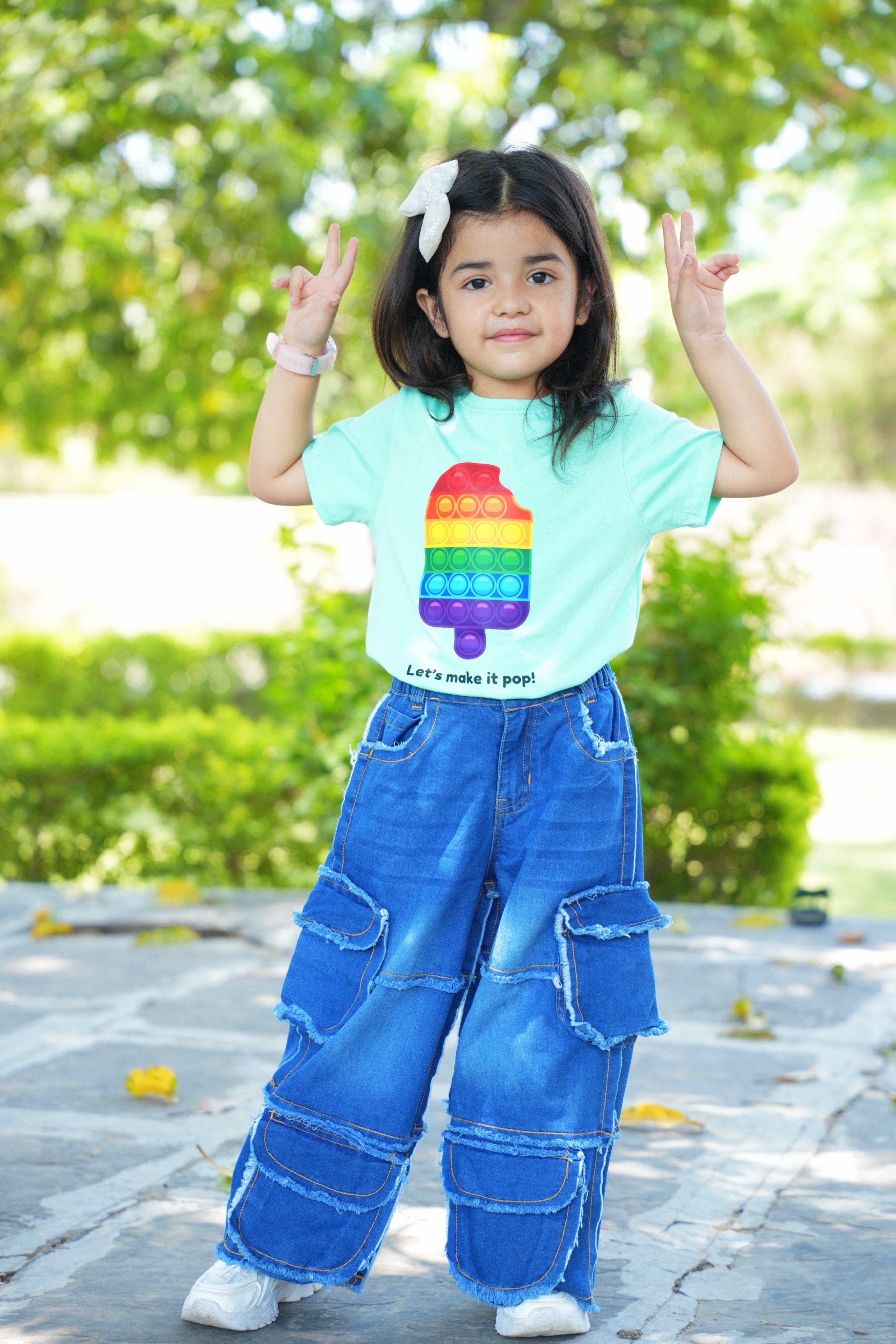 Child wearing a colorful t-shirt with a rainbow design outdoors