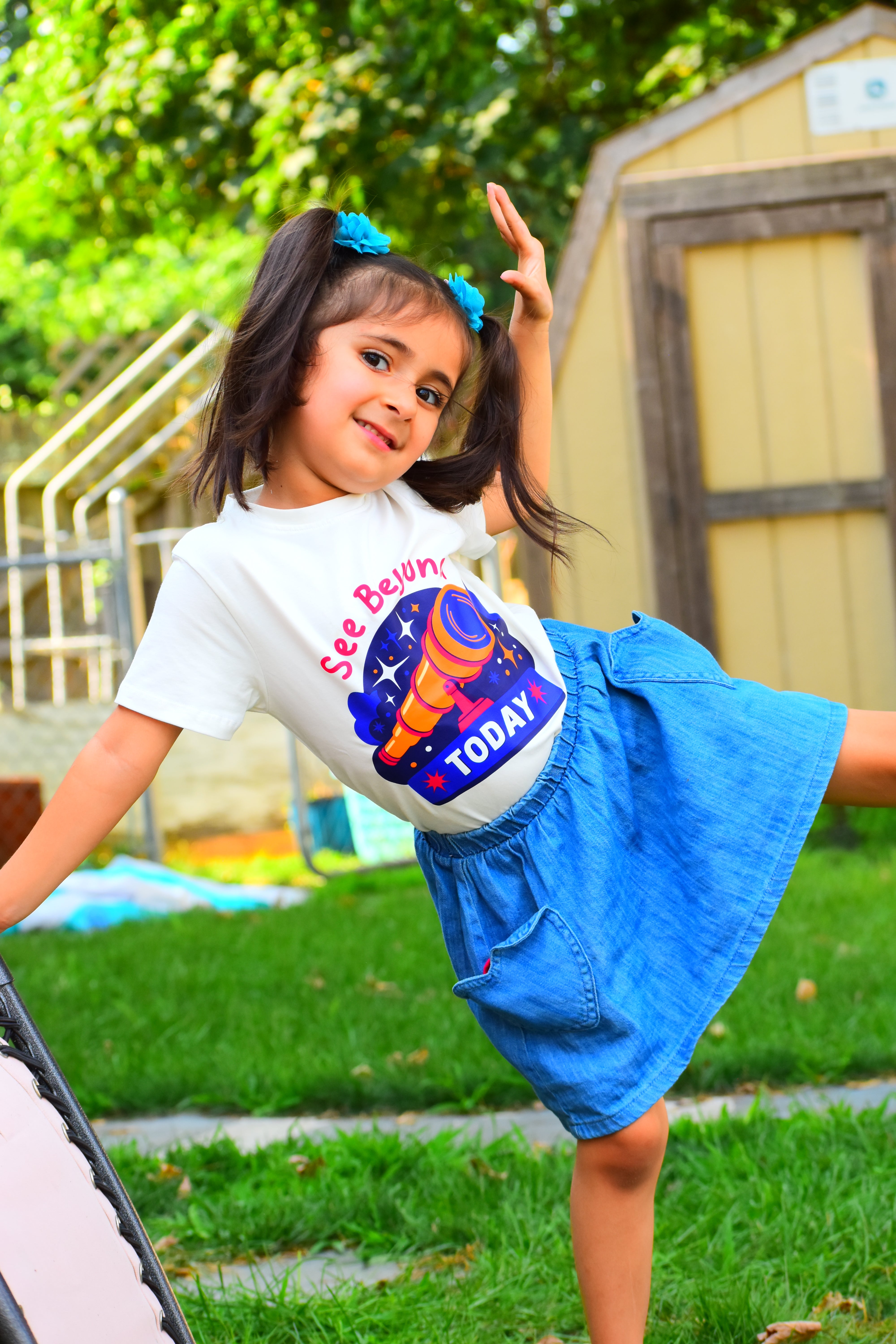 Child wearing a colorful t-shirt with text and graphics outdoors