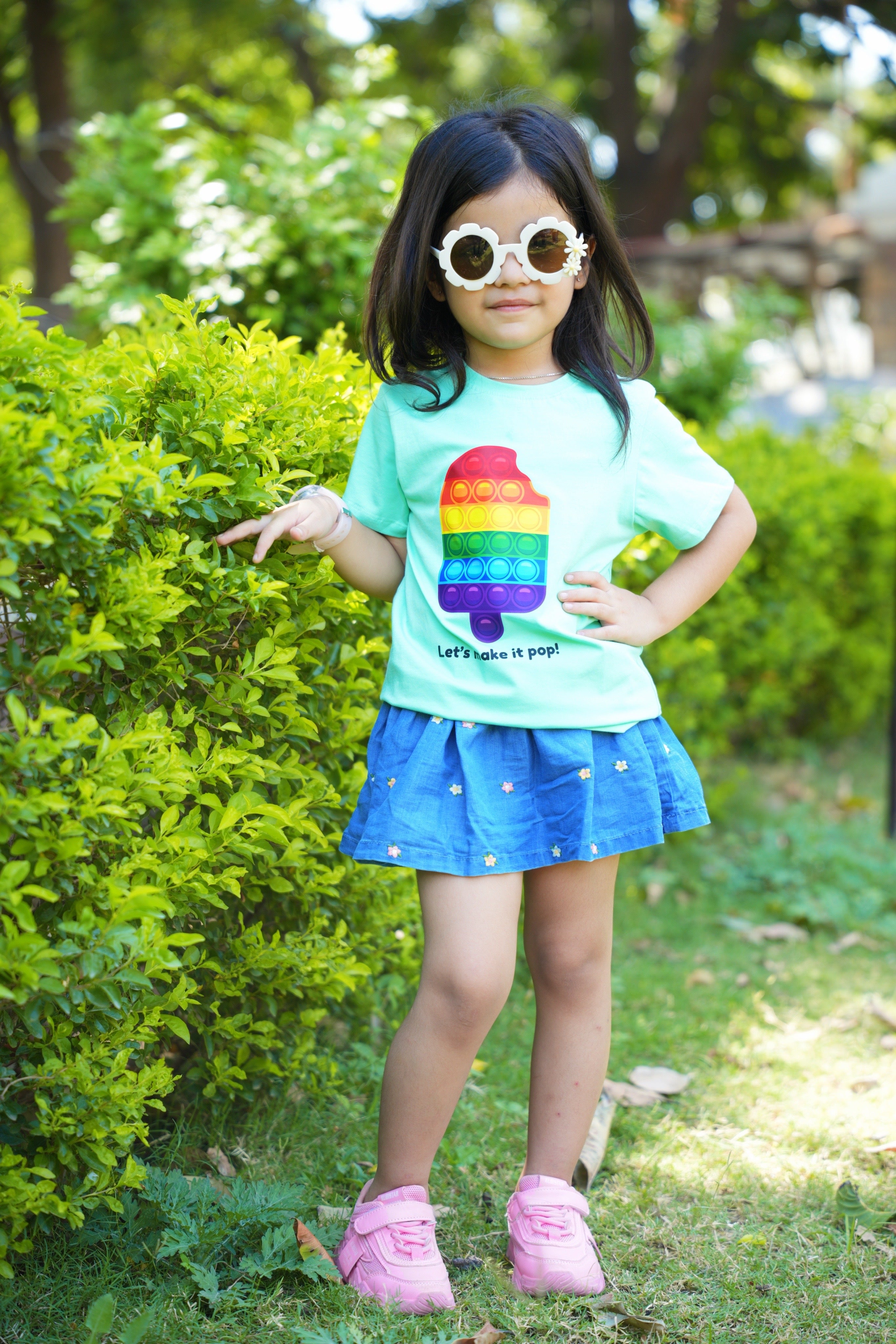 Child wearing a colorful shirt with a rainbow design outdoors