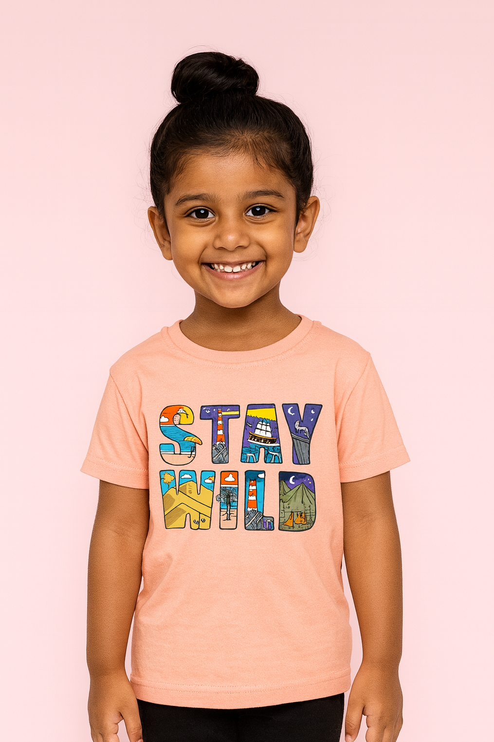 Child wearing a peach t-shirt with 'STAY WILD' text on a pink background